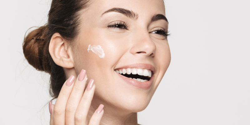 Smiling woman with cream on cheek
