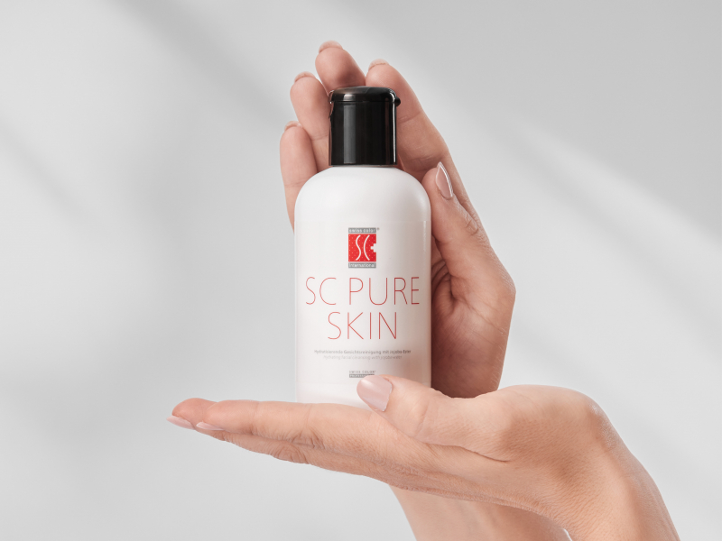 Hands holding a cleansing product for the face