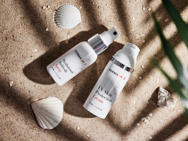 Two skin care products lying in the sand on the beach