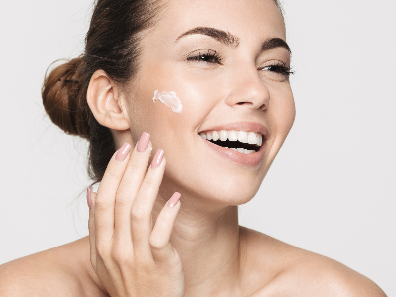 Smiling woman with cream on cheek